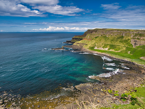 A sweep of coastal cliffs on the spectacular Antrim Coast in Northern Ireland, UK. Taken near Giant's Causeway on a sunny day in summer.