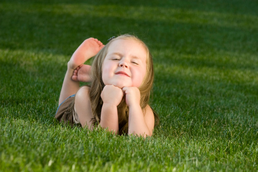 A young girl lying on the grass