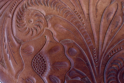 Close up of tooling on old Western style saddle.