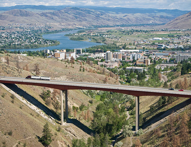 City of Kamloops "A view of the City of Kamloops, British Columbia, with the Trans-Canada Highway in the foreground. The North Thompson River is seen in the background, and Peterson Creek Park runs under the bridge." kamloops stock pictures, royalty-free photos & images