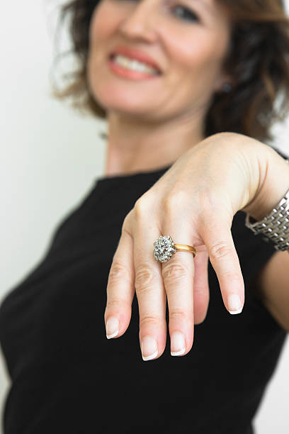 Look at my ring Mature woman showing her diamond ring with happy expression. Focus on hand. ostentation stock pictures, royalty-free photos & images