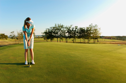 Young woman playing golf.