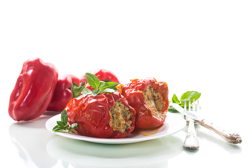 Red pepper stuffed with meat, rice and vegetables with tomato sauce and sour cream. A traditional dish. Close-up.