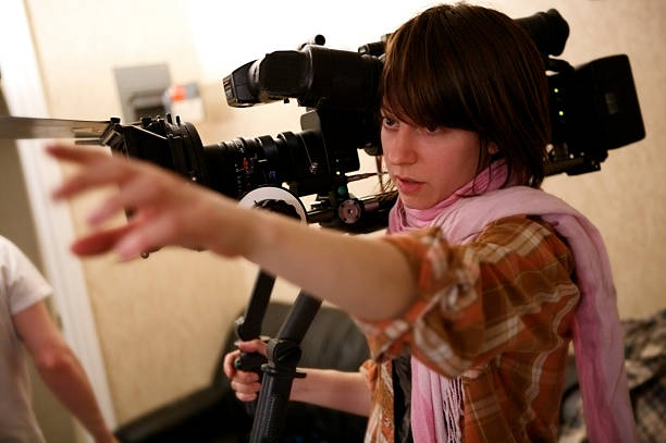 Directing the Shot A young woman directing the crew on set.More filmmaking images: film director stock pictures, royalty-free photos & images
