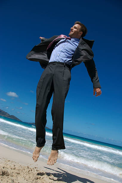 istock Businessman Leaps into the Air on Tropical Beach 172948456