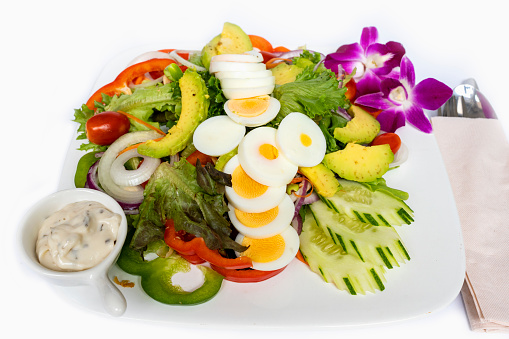 Boiled egg salad with dressing on white background. Vegan food.