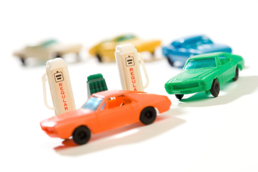 Toy automobiles on gas station line. Photographed with shallow depth of field and high contrast for effect.