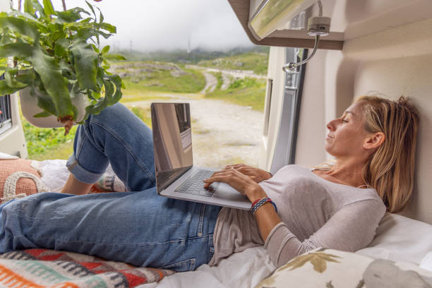 istock Woman travelling by van uses laptop 1729485373