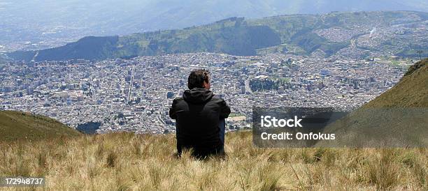 Hombre Sentado En La Cumbre De La Montaña Con Vista A La Ciudad De Quito Ecuador Foto de stock y más banco de imágenes de Quito