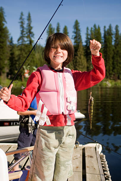 istock Little Girl Holding up Fish that she has Caught. 172948907
