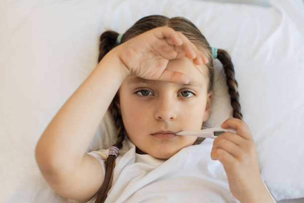 istock Exhausted caucasian girl measuring temperature in bed 1729497625