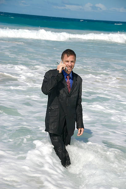 empresário embebido no telefone - stranded beached beach businessman imagens e fotografias de stock