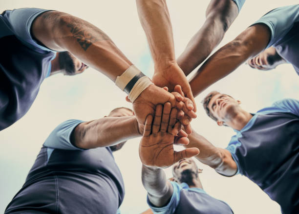 la diversité, l’équipe et les hommes avec les mains ensemble dans les sports ci-dessous pour le soutien, la motivation ou les objectifs en plein air. groupe sportif de l’homme empilant la main pour la forme physique, le travail d’équipe ou le succ - exercising motivation looking up african descent photos et images de collection