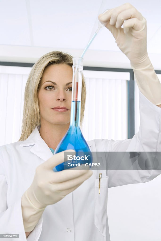 Scientist Woman Working In A Laboratory Measuring "Scientist woman working in a laboratory measuring cooper solutionThis photo has been produced on location with these professionals : make-up artist, hair dresser and stylist. A professional retoucher gave it the final magic touch." Adult Stock Photo
