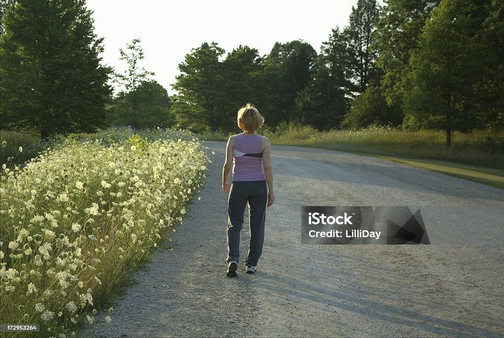Walking Down the Road Woman walking for exercise 40-49 Years Stock Photo