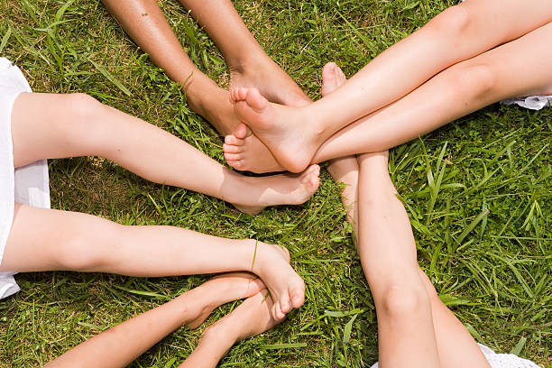 istock Five girls' legs form a star shape in the grass 172953368