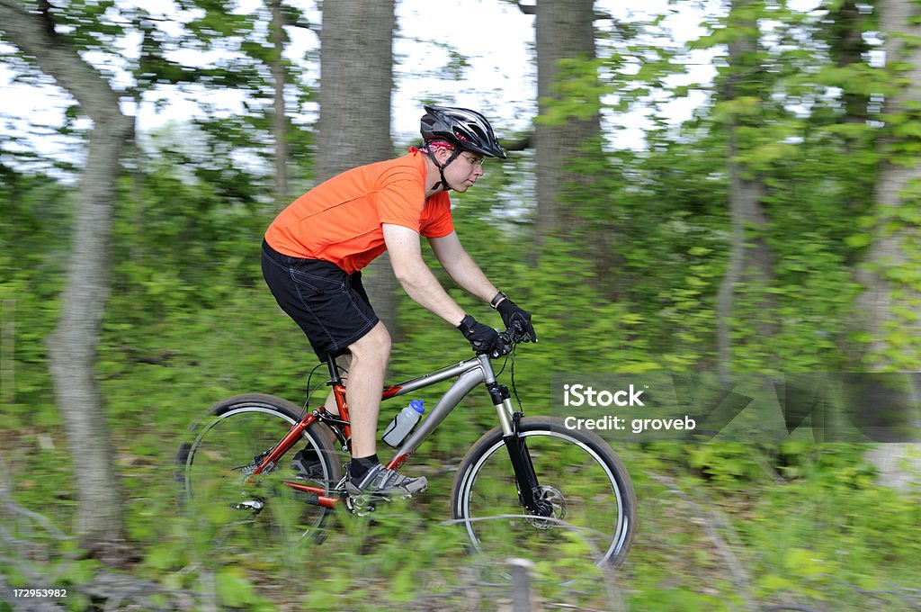 riding a través de ciclista de montaña en el bosque. - Foto de stock de Accesorio de cabeza libre de derechos