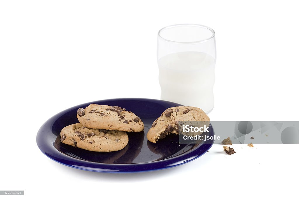 Milk and chocolate chip cookies with bite missing A glass of milk and a plate of chocolate chip cookies with one mostly eaten.  Was this left out for Santa  Image includes a clipping path and is isolated on a white background. Celebration Event Stock Photo