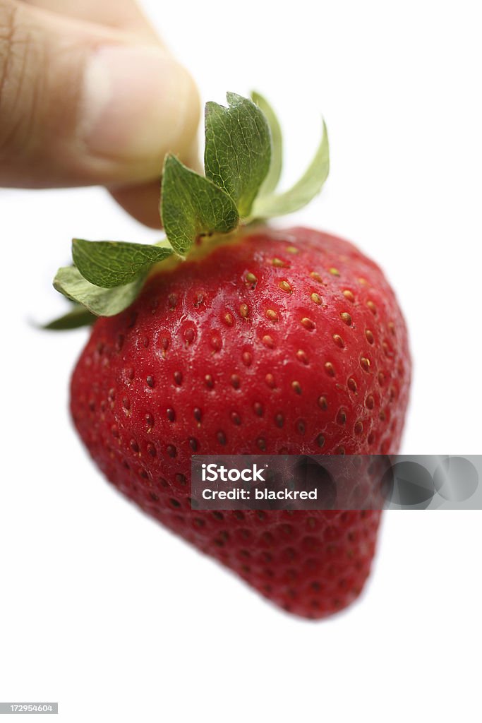 Strawberry Hand holding a strawberry, isolated on white background. Clean Stock Photo