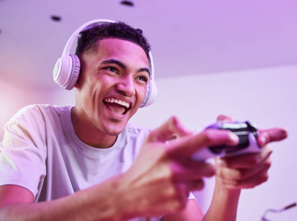 istock Headphones, esports and man playing video game online with controller winning virtual challenge and excited in celebration. Internet, user experience and person or gamer streaming sports games 1729549217