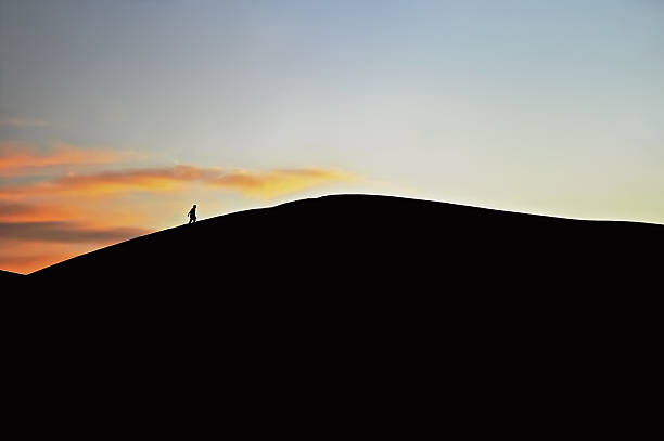 istock Silhouetted Hiker and Sand Dunes in Sahara Desert, Morocco 172955597