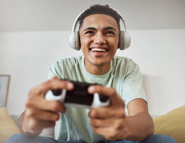 istock Headphones, esport and man happy for video game online with controller playing virtual challenge and excited in living room. Internet, user experience and person or gamer streaming sports games 1729559072