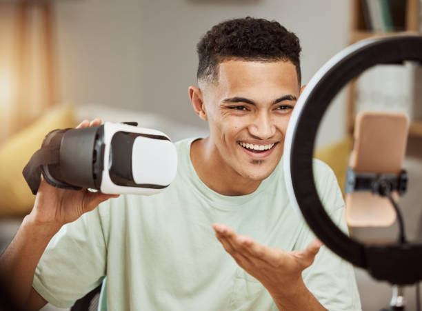 istock Ring light, influencer and man with virtual reality headset review in his home live streaming to blog or podcast. Social media, feedback and male gamer with vr goggles for esports, gaming or update 1729559082