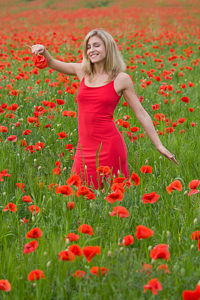 beautiful woman in poppy flowers beautiful young woman smelling in a bright poppy field ... jacraa2007 stock pictures, royalty-free photos & images