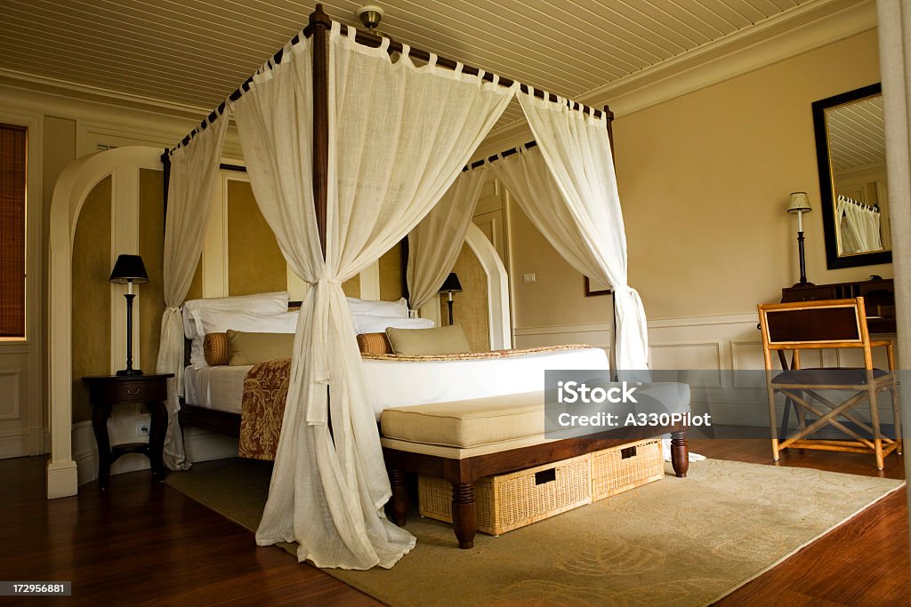 Double bed with white curtains Four poster bed in a tropical resort. Four-Poster Bed Stock Photo