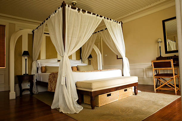 Double bed with white curtains Four poster bed in a tropical resort. luxury canopy beds stock pictures, royalty-free photos & images