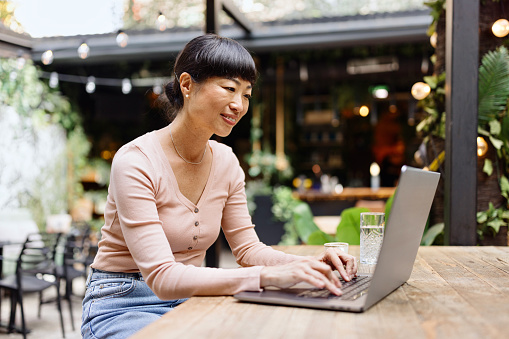 Modern woman typing something on her computer at the caffe