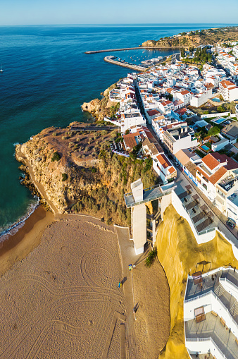 aerial view on praia dos pescadores with elevator and harbor in the background in Albufeira, Portugal at sunrise hour