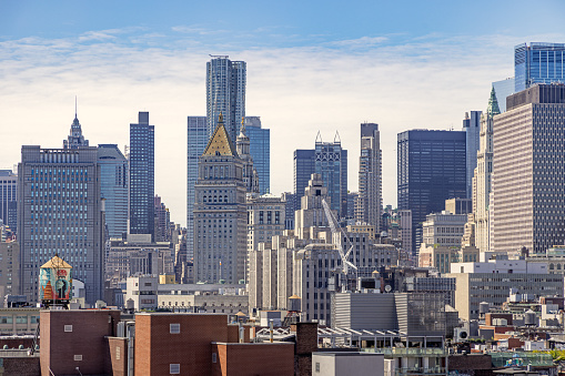 The Bowery, Manhattan, New York, USA - August 23th 2023: View to the skyline at the south end of Manhattan with new and old high rise buildings, seen from a rooftop on a clear summer day with almost blue sky