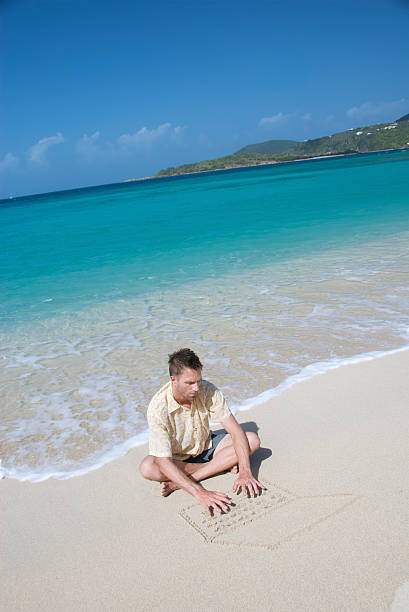 turista sentado escrevendo na areia computador portátil - computer humor stranded business imagens e fotografias de stock