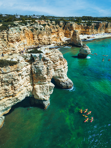 aerial view on coastline with famous rock formation in Algarve, Portugal, in the background the Praia da Marinha