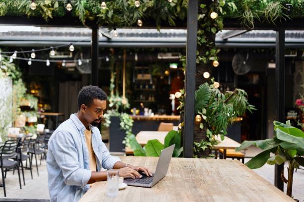 Productive man working on a laptop at the cafe