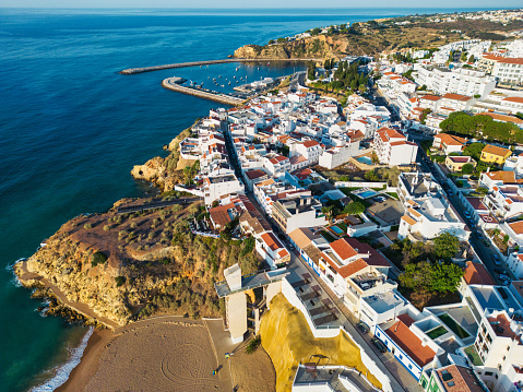 aerial view on praia dos pescadores with elevator and harbor in the background in Albufeira, Portugal at sunrise hour