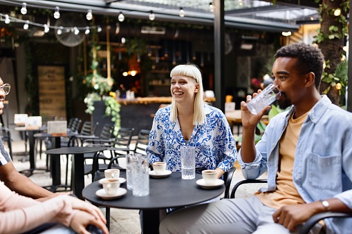 Smiling group of multiracial people having a coffee at the cafe