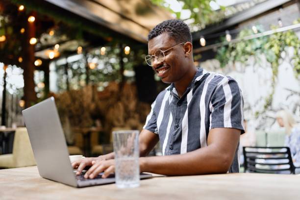 Productive black man working on his laptop at the cafe