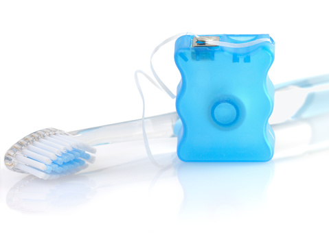 High-key shot of toothbrush and dental floss on white background