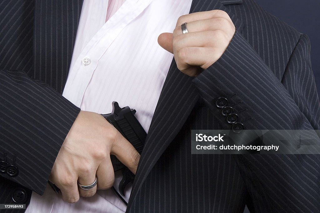 Geschäftsmann im Anzug hält eine Pistole - Lizenzfrei Abfeuern Stock-Foto