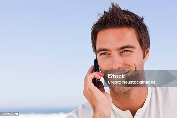 Happy Young Man Using Cell Phone Against Blue Sky Stock Photo - Download Image Now - 20-24 Years, 20-29 Years, Adult