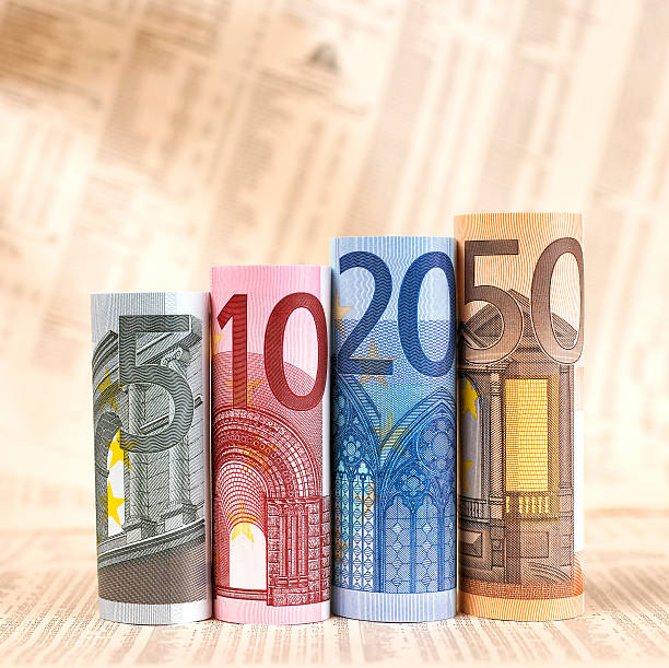 notas de euro enroladas no jornal financeiro - nota de vinte euros - fotografias e filmes do acervo
