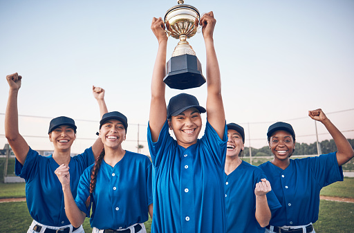 Trophy, baseball and winning team portrait with women outdoor on a pitch for sports competition. Professional athlete or softball player group celebrate champion prize, win or achievement at a game