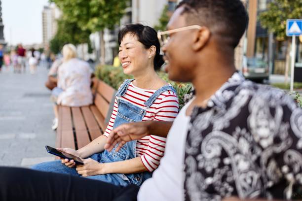 istock Joyful friends relaxing on the bench 1729597276