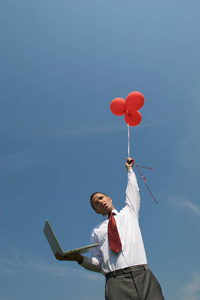 homme d'affaires avec rouge, ballons et ordinateur portable - computer humor stranded business photos et images de collection