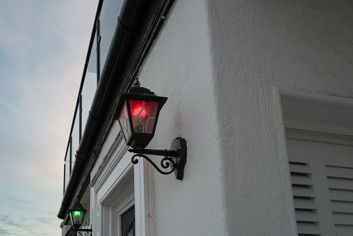 A pair of coloured lanterns, seen in the shipping anti collision colours. Located on a beach front home in the East of England.