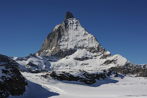 Matterhorn mountain peak in Alps in winter with snow and clear blue sky in Cervinia, Italy and Zermatt, Switzerland. Beautiful and magnificent landscape