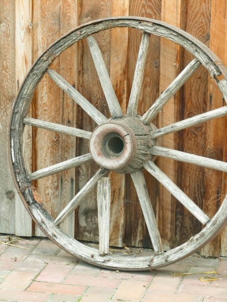 istock Antique farm wagon wheel on a rustic wall 1729612297