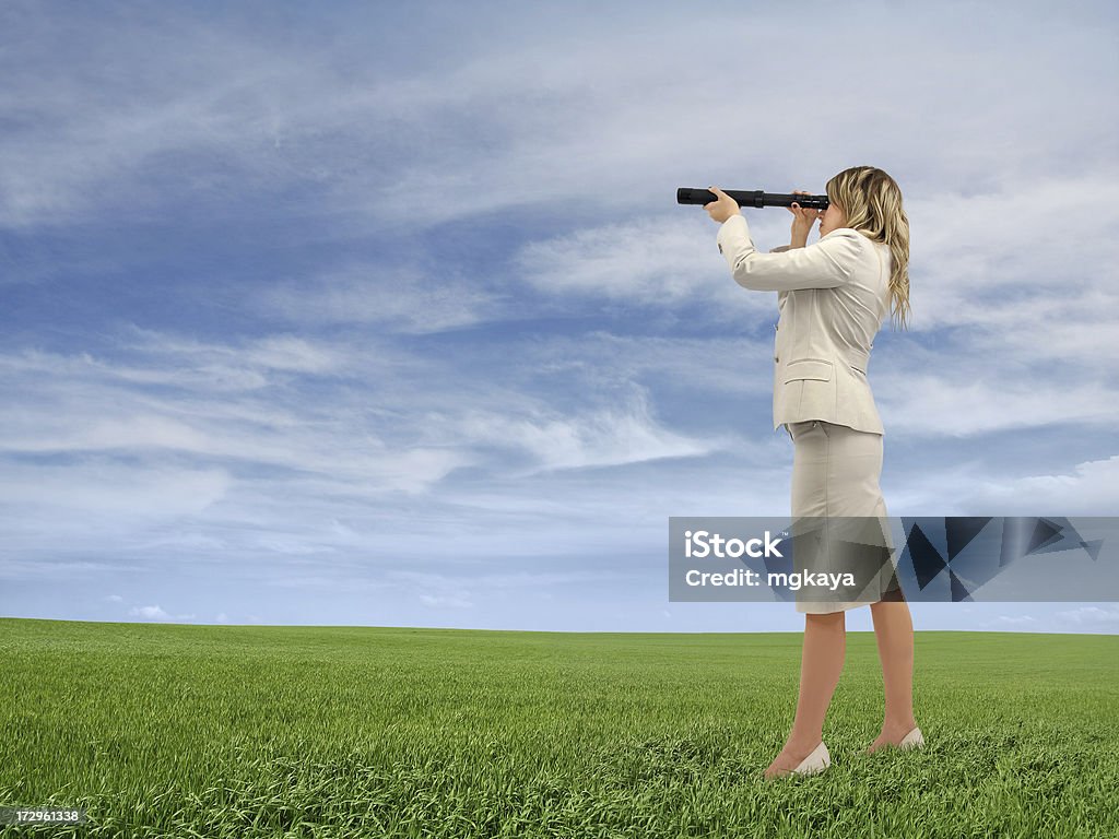 Businesswoman Looking Through a Telescope Side view of young businesswoman looking through a telescope on grass with cloudy sky background. Adult Stock Photo